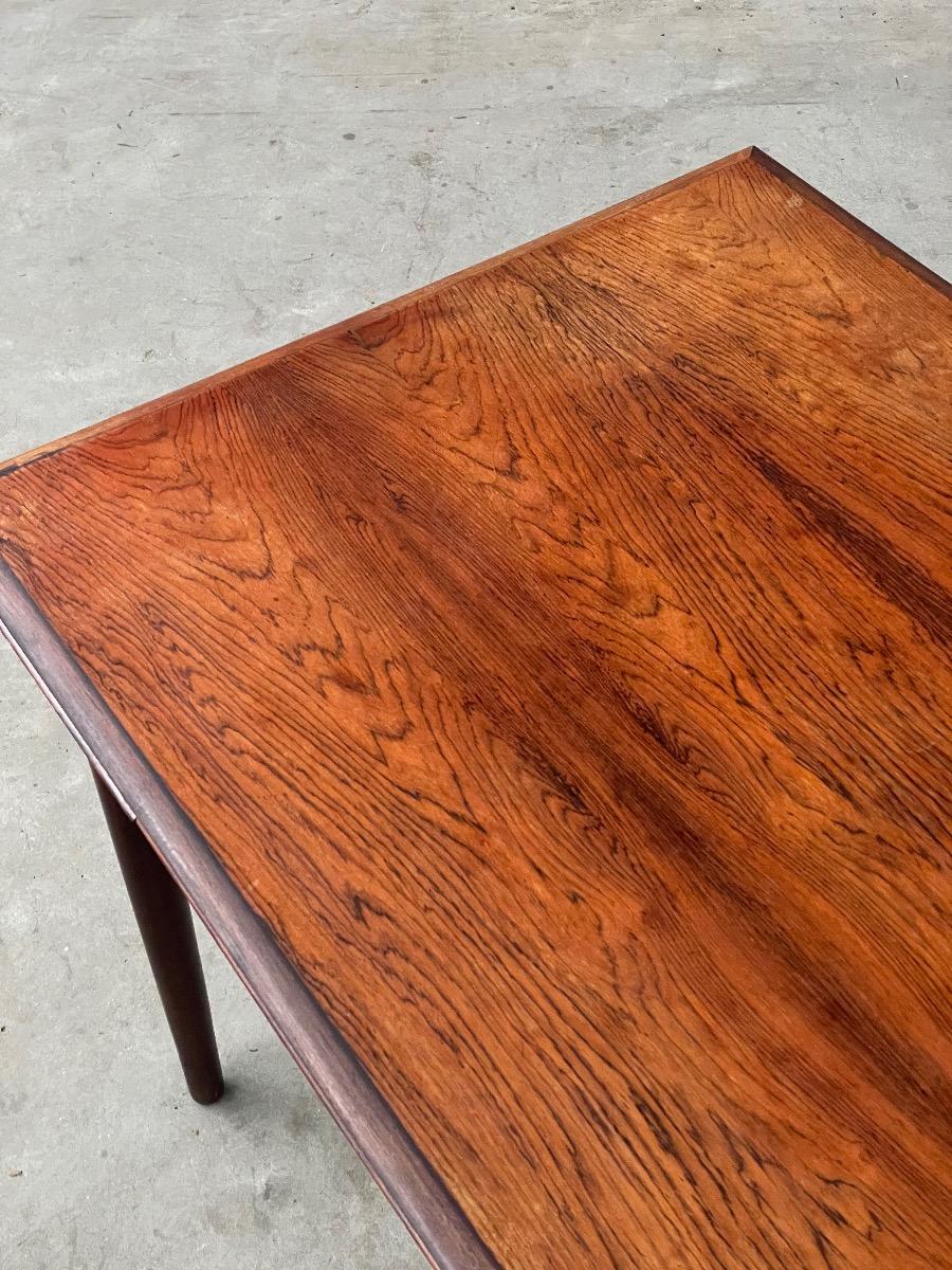 This vintage rosewood dining table is a fine example of Danish design, combining timeless aesthetics with practical functionality. The warm rosewood features a rich grain and characterful colour, giving the table an elegant and inviting appearance. With e