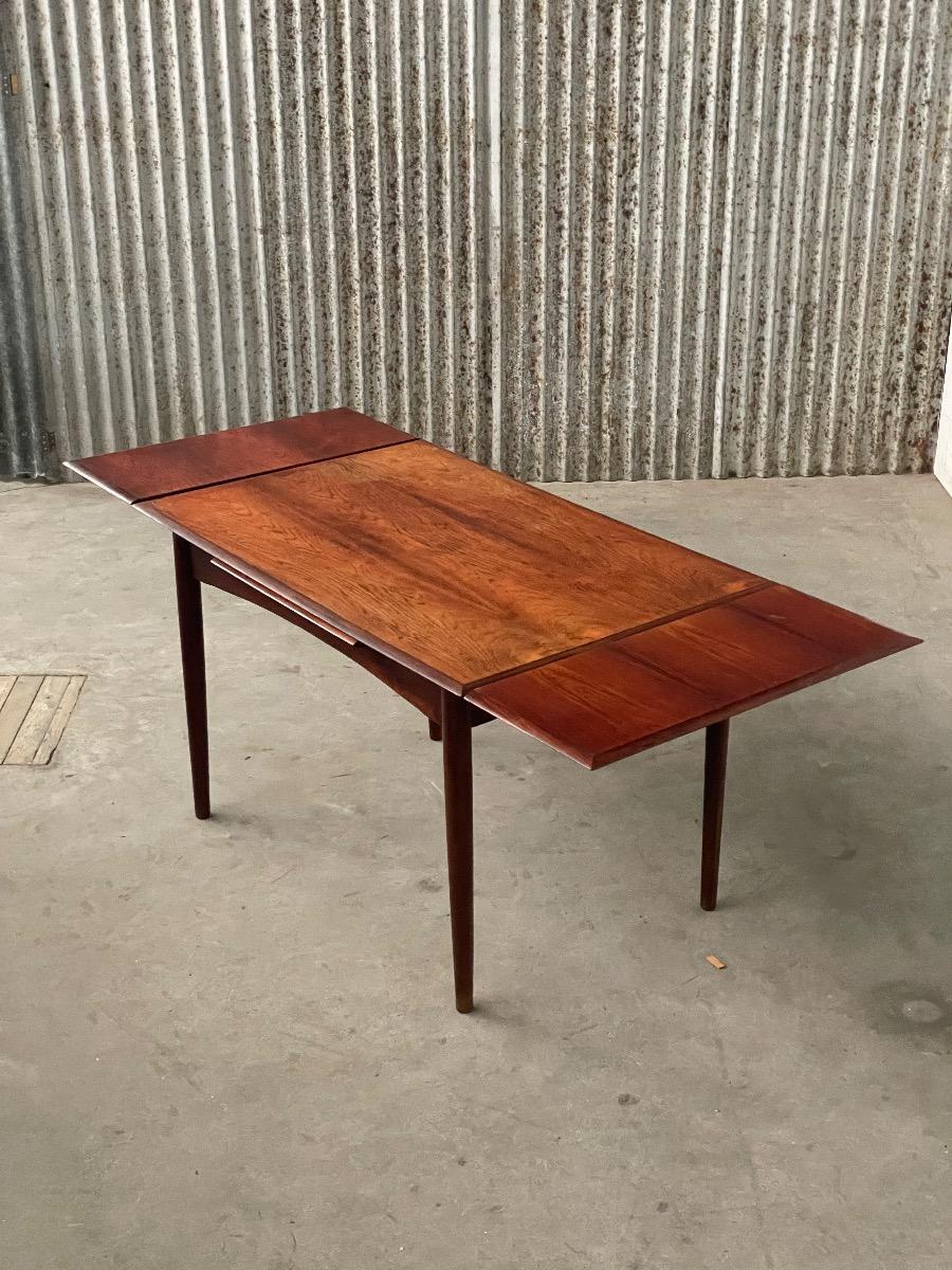 This vintage rosewood dining table is a fine example of Danish design, combining timeless aesthetics with practical functionality. The warm rosewood features a rich grain and characterful colour, giving the table an elegant and inviting appearance. With e